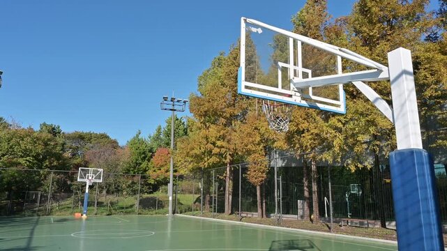 맑고 푸른 하늘 아래 공원에 위치한 빈 야외 농구장(Empty outdoor basketball court in a park under clear blue sky in Korea.)