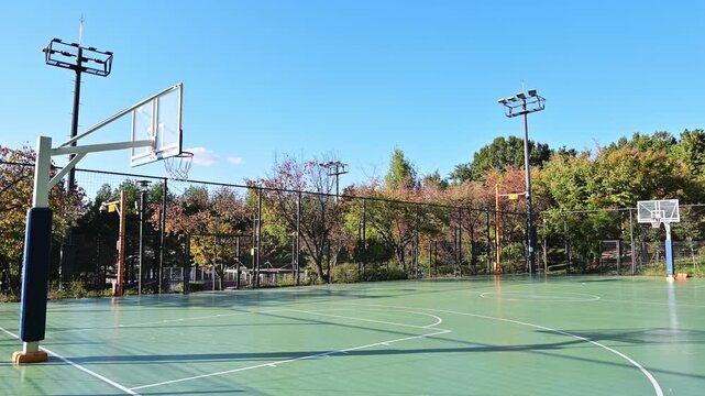 맑고 푸른 하늘 아래 공원에 위치한 빈 야외 농구장(Empty outdoor basketball court in a park under clear blue sky in Korea.)
