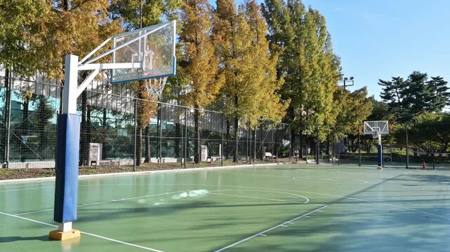 맑고 푸른 하늘 아래 공원에 위치한 빈 야외 농구장(Empty outdoor basketball court in a park under clear blue sky in Korea.)
