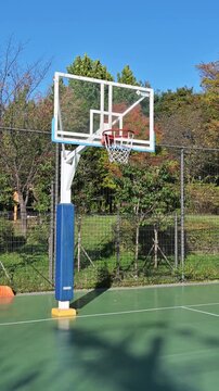 맑고 푸른 하늘 아래 공원에 위치한 빈 야외 농구장(Empty outdoor basketball court in a park under clear blue sky in Korea.)