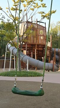 야외 어린이 놀이터에 있는 빈 초록색 그네와 미끄럼틀 놀이기구(Empty green swings and slide play equipment at outdoor children playground in Korea)