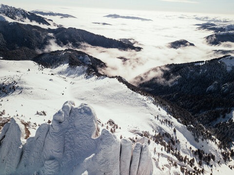 Snow sculpted rock pillars above a cloud inversion in Romania