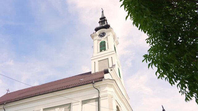 Low-angle view of the historic bell tower of a serbian orthodox church in Baja, Hungary