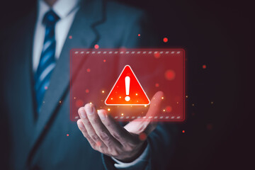 Cybersecurity risk warning on a laptop screen as hands interact with digital code, highlighting software vulnerabilities, system errors, data protection, and information security. © wanchai peatoo