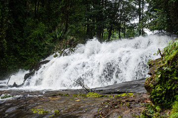 Waterfall cascading over dark rocks in Thailand © Emad Aljumah