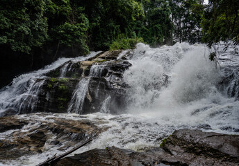 Waterfall cascading over dark rocks in Thailand © Emad Aljumah
