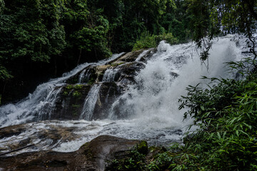 Waterfall cascading over dark rocks in Thailand © Emad Aljumah