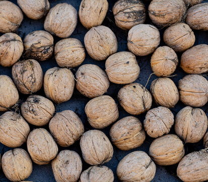 A pile of walnuts on a black surface