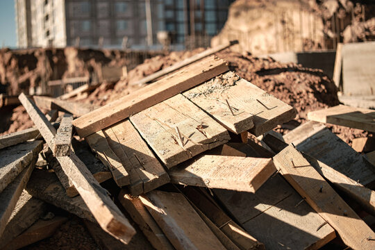 Formwork boards and tools lie beside concrete work at a building site in an urban area during construction