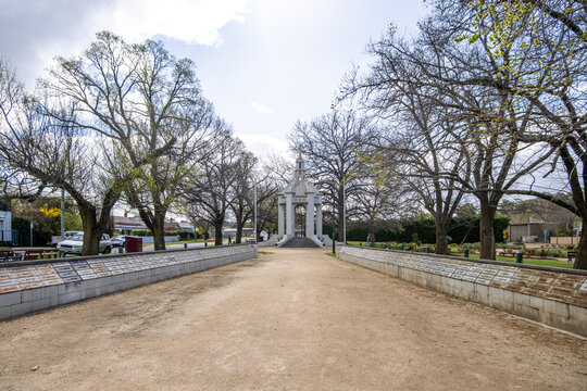 A broad gravel forecourt leads toward the war memorial monument at the Beaufort Memorial Garden in Beaufort, Victoria, Australia.  A formal ceremonial and civic commemoration space in regional town
