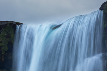 Öxarárfoss Waterfall Beneath Dramatic Clouds in Iceland © aruizhu