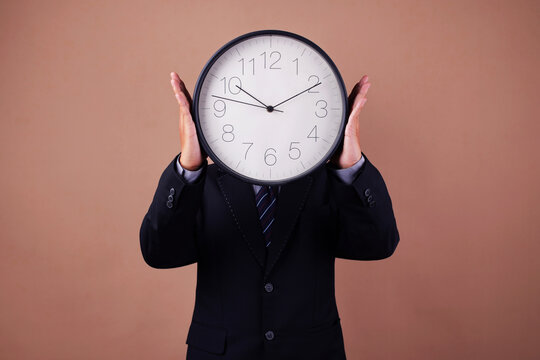 Businessman Holding Wall Clock in Front His Face in Creative Conceptual Collage Art