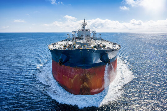 Front view of the bow of a large crude oil cargo tanker ship traveling fast over the ocean