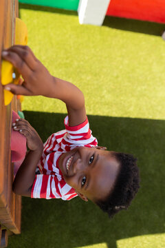 Schoolboy climbing a wall in the school playground