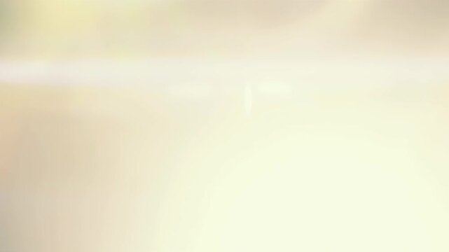 Golden cream anamorphic lens flare growing and flooding the frame with warm white light, horizontal streak and oval bokeh, cinematic light leak transition for video editing