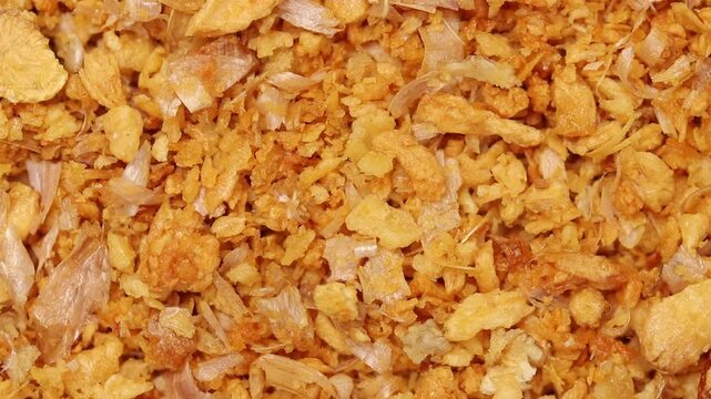 Close-up of crispy fried chopped garlic with skins rotating slowly, top view shot, thai food ingredient