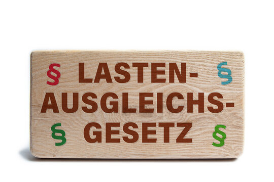 Holzklotz mit der Aufschrift Lastenausgleichsgesetz und Paragraphenzeichen
