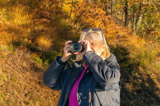 Woman Taking Photos in an Autumn Forest

A woman photographs the golden autumn scenery with a camera on a sunny day. The warm foliage and natural light create a bright seasonal outdoor scene.