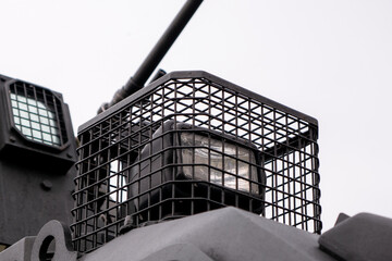 Low angle view of automated security turret mechanism with optical sensor lens and protective metal mesh grid grill on vehicle roof © MarijaBazarova