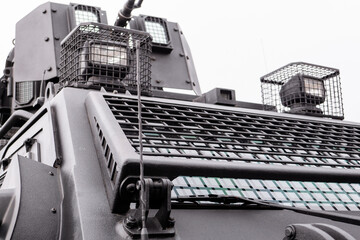 Low angle view of automated security turret mechanism with optical sensor lens and protective metal mesh grid grill on vehicle roof © MarijaBazarova