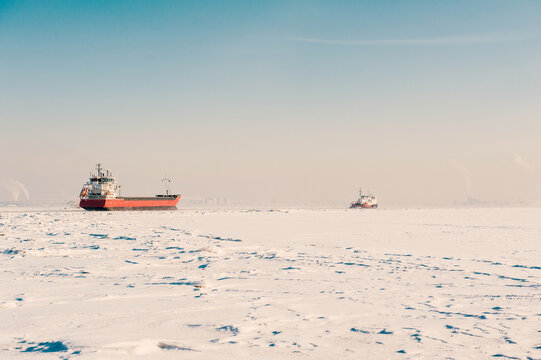 Winter shipping. Big cargo ships in frozen sea fairway