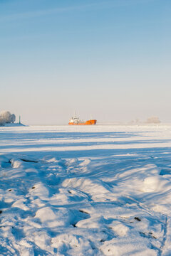 Winter shipping. Big cargo ship in frozen sea fairway