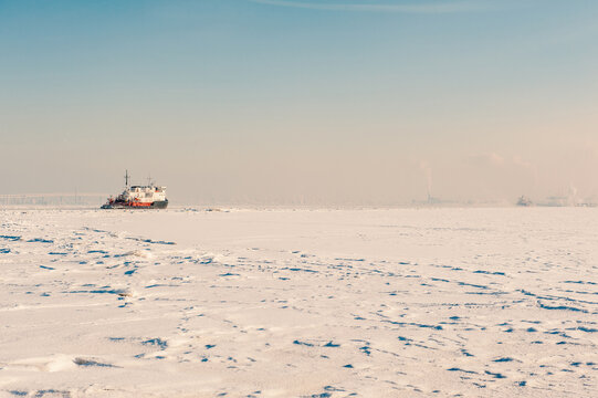 Winter shipping. Big cargo ship in frozen ice fairway
