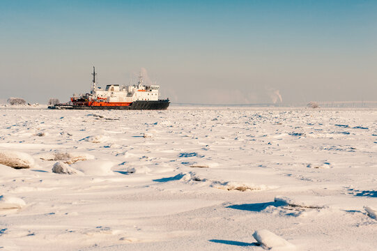 Winter shipping. Big cargo ship in frozen ice fairway