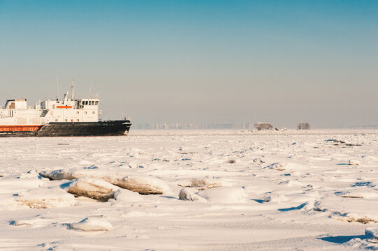 Winter shipping. Big cargo ship in frozen sea fairway