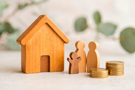 A small wooden house with a family figurine and gold coins