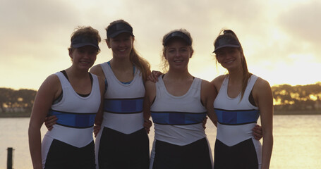 Portrait of four caucasian female rowers embracing by river with copy space © WavebreakMediaMicro