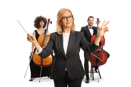 Female orchestra conductor with a baton in front of cello players