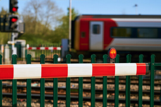 railway track barrier with train in the background 