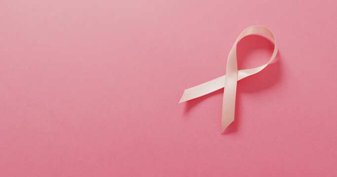 Image of pink breast cancer ribbon on pale pink background