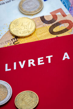 Livret A avec des pi&egrave;ces de monnaie et des billets en euros. Le livret A est un compte &eacute;pargne fran&ccedil;ais r&egrave;glement&eacute; dont le taux d'int&eacute;r&ecirc;t et le plafond de d&eacute;p&ocirc;t sont d&eacute;finis par le gouvernement