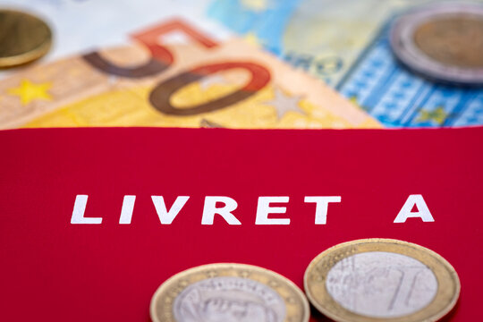 Livret A avec des pi&egrave;ces de monnaie et des billets en euros. Le livret A est un compte &eacute;pargne fran&ccedil;ais r&egrave;glement&eacute; dont le taux d'int&eacute;r&ecirc;t et le plafond de d&eacute;p&ocirc;t sont d&eacute;finis par le gouvernement