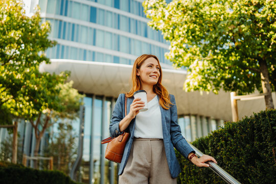 Businesswoman enjoying coffee outside a modern office building