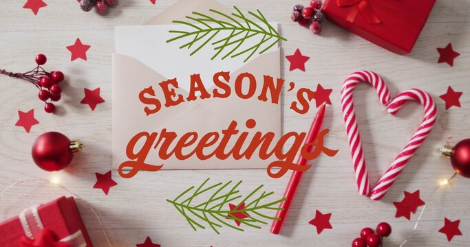 Showing centered envelope and greeting card on light wood table, with candy-cane heart and pencil