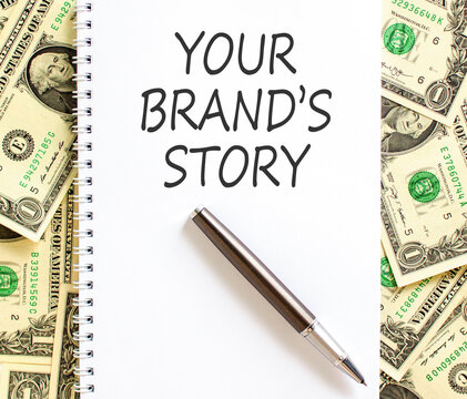 Branding and your brands story symbol. Concept words Your brands story on beautiful white note. Beautiful dollar bills background. Business branding your brands story concept. Copy space.