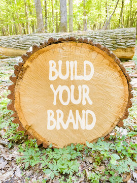 Build your brand words symbol. Concept words Build your brand on beautiful wooden circle. Beautiful green forest background. Business and build your brand concept. Copy space.