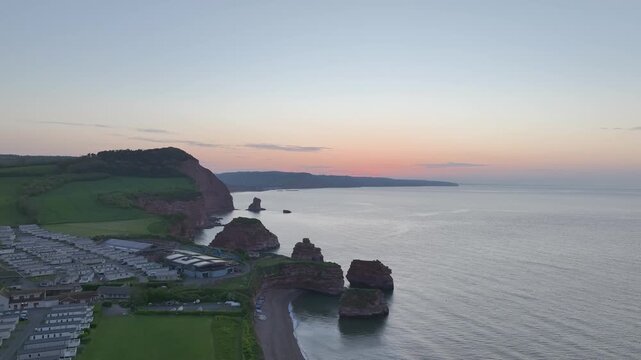 Aerial view of sea stacks and red cliffs at dawn in Ladram Bay, Devon, England
