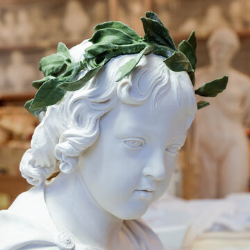 White cherub sculpture bust with laurel wreath 