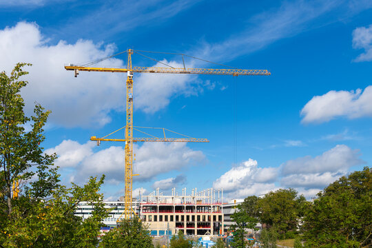Large yellow tower cranes working at building construction site