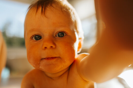 Close-up shot of shirtless baby boy covered in saliva around mouth