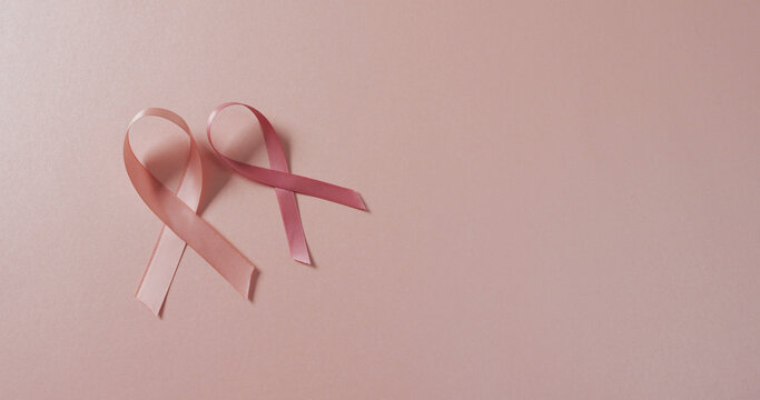 Image of two pink breast cancer ribbons on pale pink background