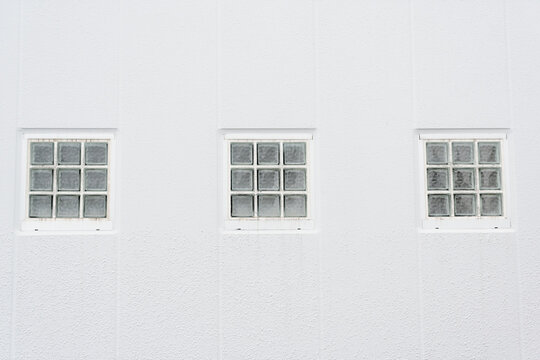 Three Glass Block Windows on a Textured White Wall
