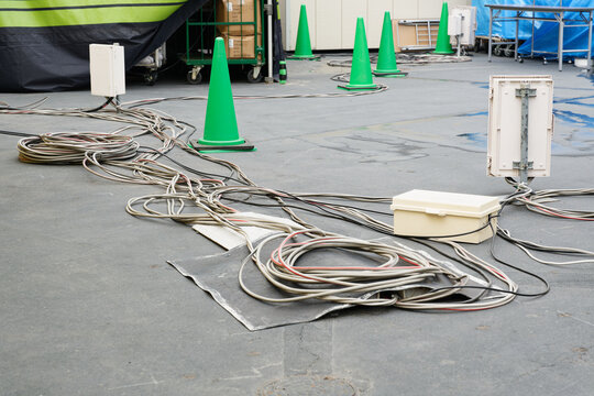 Coiled Cables and Green Safety Cones on a Worksite Floor