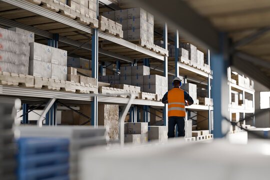 3D logistics worker inspecting warehouse shelving and inventory management system