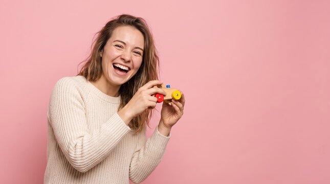 Happy young woman playing with small toy car