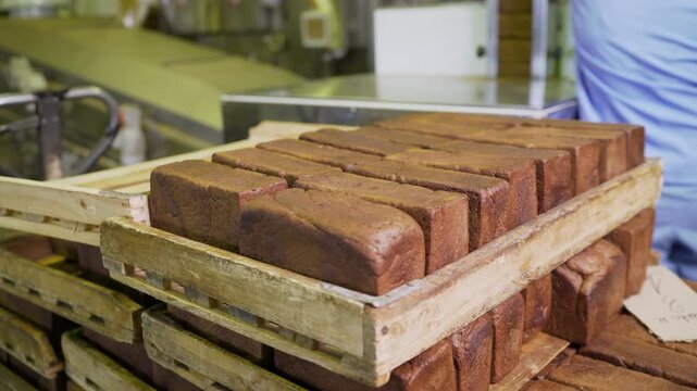 Freshly baked bread loaves are neatly arranged in wooden crates, showcasing efficient bakery storage and organization techniques